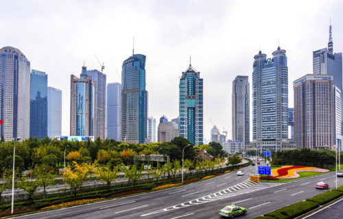 A panoramic view of Shanghai, China, showcasing its iconic skyline and modern architecture against a clear blue sky.