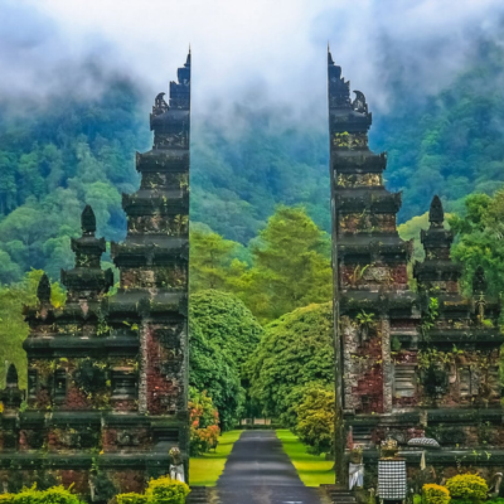 The entrance to a temple in Ubud, Bali, featuring intricate carvings and lush greenery surrounding the pathway.