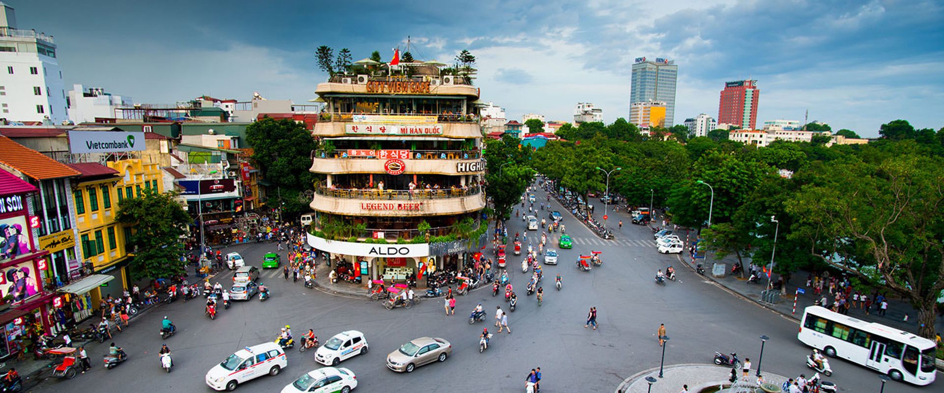 A bustling city street filled with numerous cars and pedestrians navigating through the vibrant urban environment.